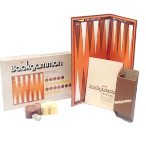 May include: A vintage backgammon game set in a brown box with a wooden game board, dice, and playing pieces. The box includes instructions for playing the game.
