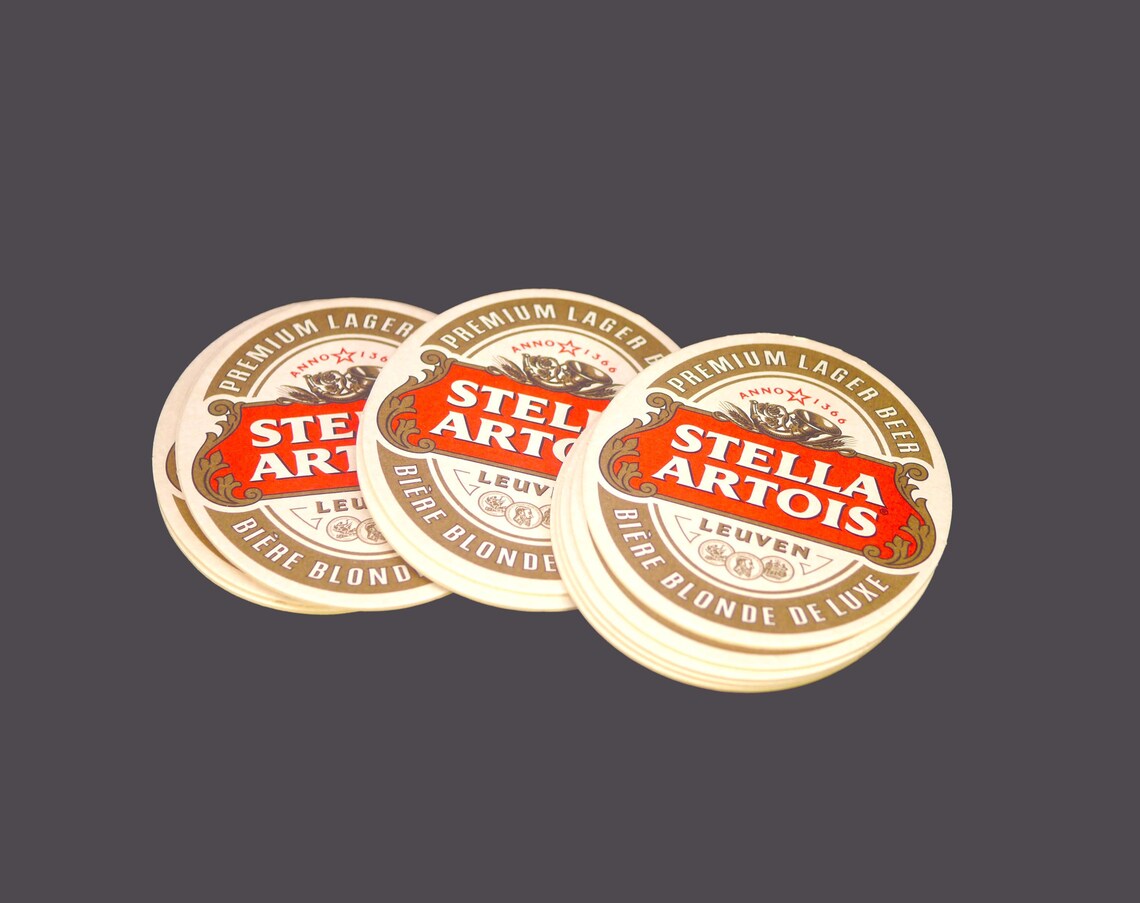 Twelve Stella Artois Biere Blonde Deluxe Oval Cardboard Coasters. Great