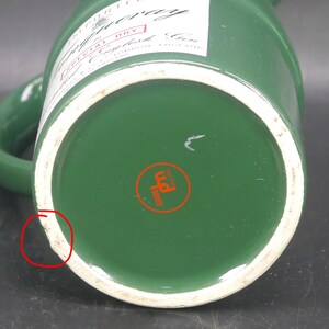 May include: Green ceramic pitcher with a white rim and a label that reads "IMPORTED" "Gilbey's" "SPECIAL DRY" "English Gin" and "MADE & BOTTLED IN ENGLAND". The bottom of the pitcher has a red circle with the word "WARRE" and a symbol inside.