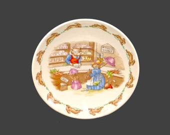 Royal Doulton Bunnykins orphaned saucer only made in England. The bunnies shopping at Mr. Piggly's store.