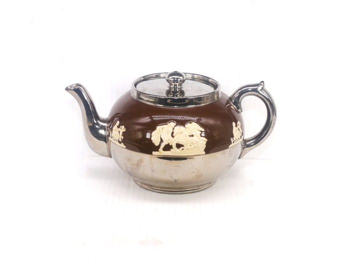 Gibsons 4699 four-cup teapot made in England. High-relief Greco-Roman scenes on brown, platinum accents. Flaws (see below).