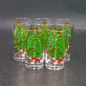 May include: Set of six clear glass tumblers with a Christmas tree design. Each glass features a green Christmas tree with red ornaments, a star on top, and white figures at the base.