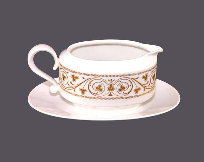 Heinrich gravy boat with attached under-plate made in Germany. Gold scrolls, clovers on white. Minor flaw (see below).