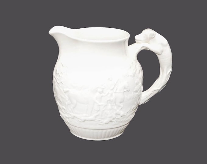 Wedgwood Devonshire 50-ounce pitcher made in England. Embossed hunt scenes, dog handle. Flaw (see below)