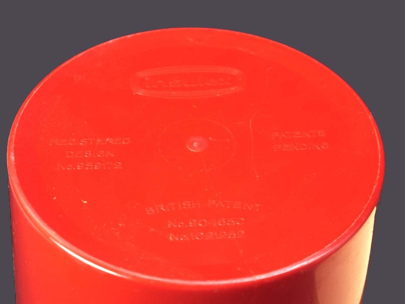 May include: Red plastic container with the text "Insinkerator" and "Registered Design No. 859172", "British Patent No. 804650", and "Patents Pending" printed on the bottom.