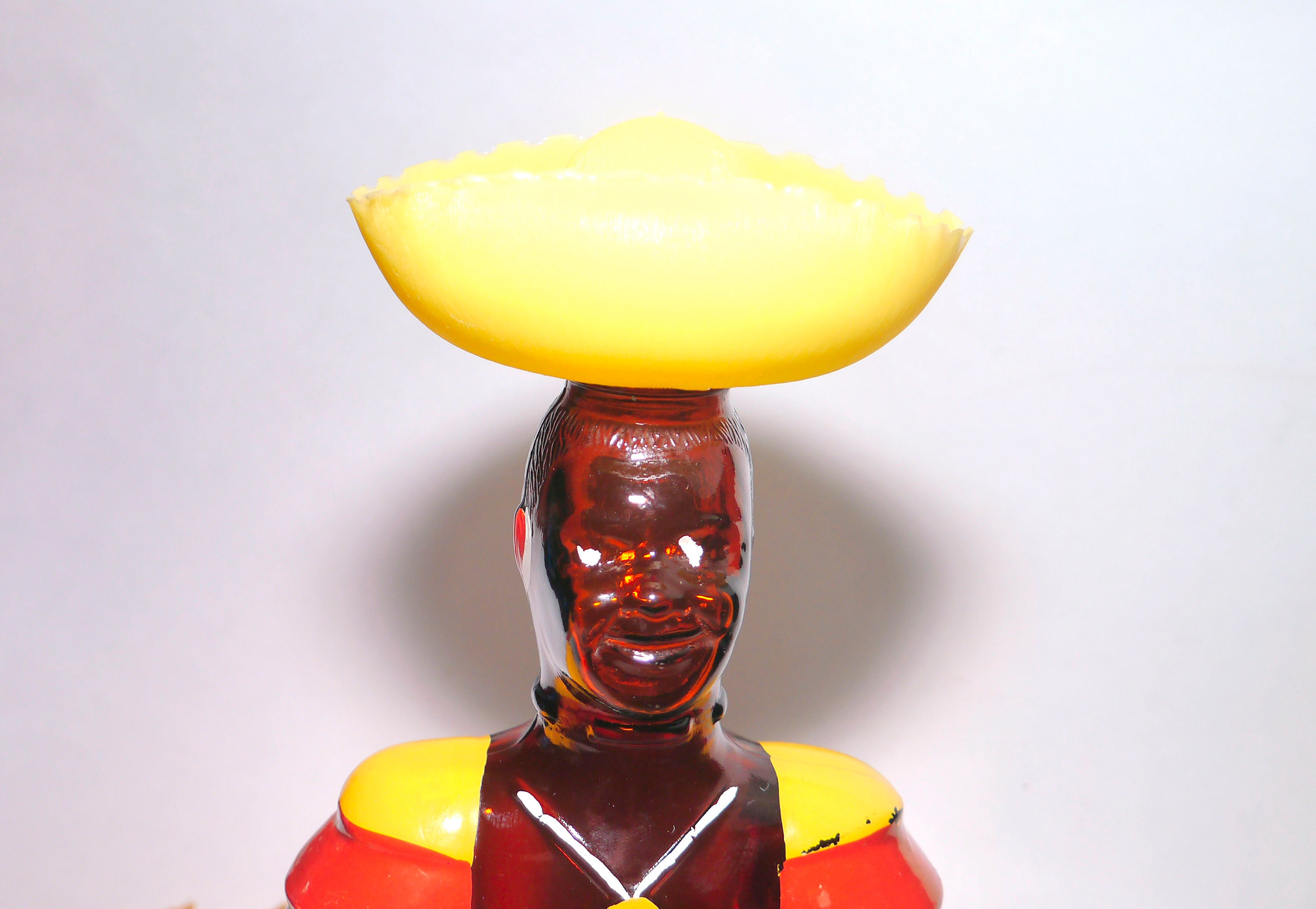 Old Oak Rum empty Limbo Drummer bottle. Original yellow plastic Sombrero lid. Made by Angostura