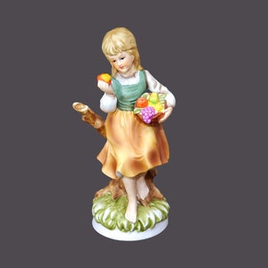 Giftcraft porcelain bisque figurine. Young girl holding fruit. Made in Japanese Taiwan.