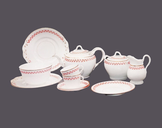 Art-deco partial tea service pattern 666. Hand-decorated orange crossed lines on white, gold edge. Attributed France. Flaws (see below).