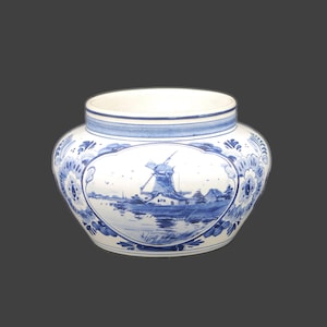 May include: A white ceramic vase with a blue and white Delft design featuring a windmill and floral motifs.
