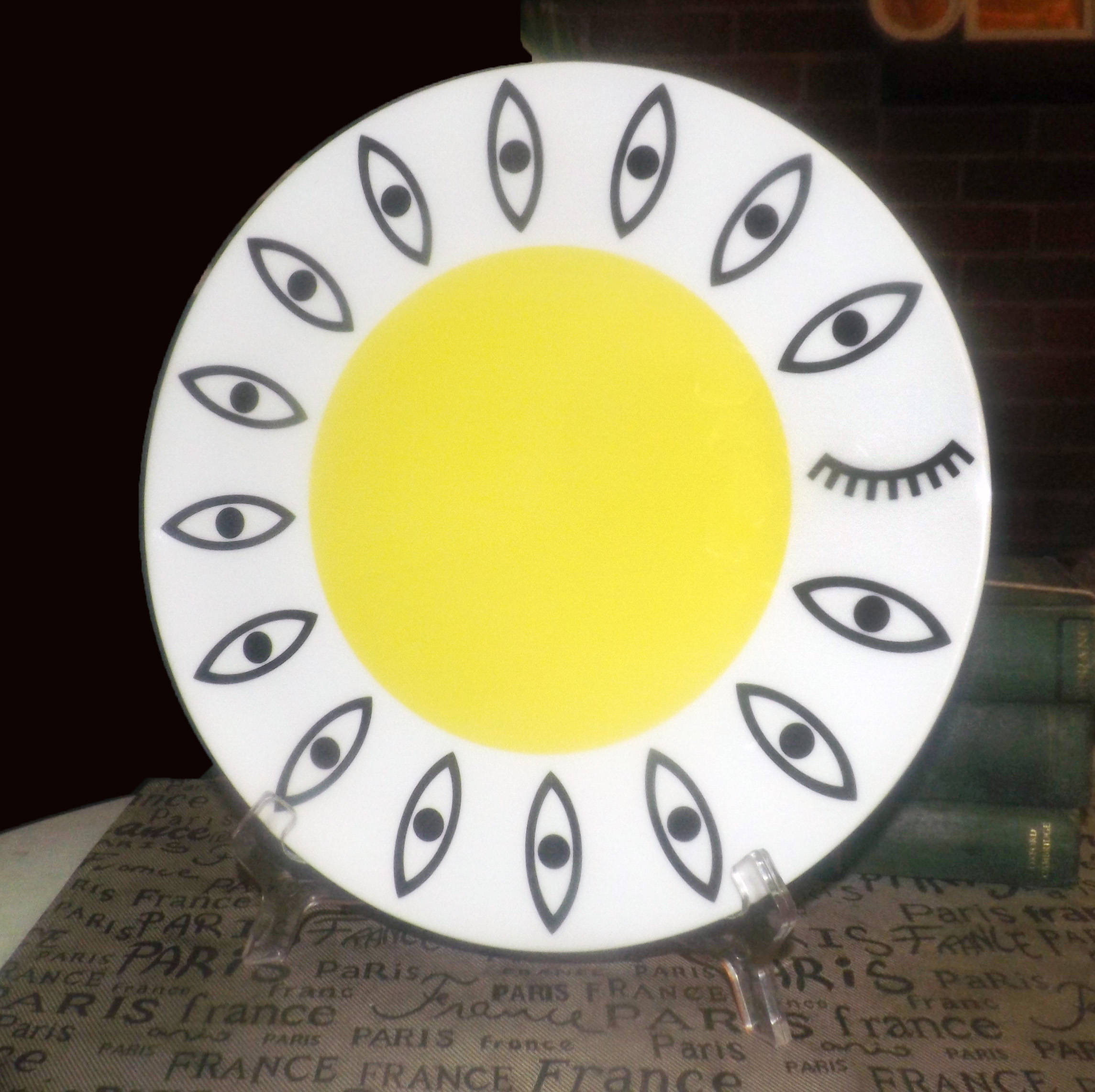 IKEA Gloedande Glodande 23102 dinner plate charger. Black eyes, eyelash, yellow center