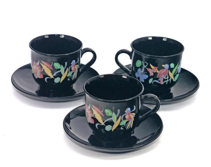Three Arcoroc Arcopal cup and saucer sets. Multicolor florals and tropical birds on black glass. Made in France.