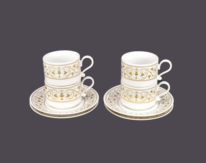 Four Heinrich cup and saucer sets made in Germany. Gold scrolls and clovers on white.
