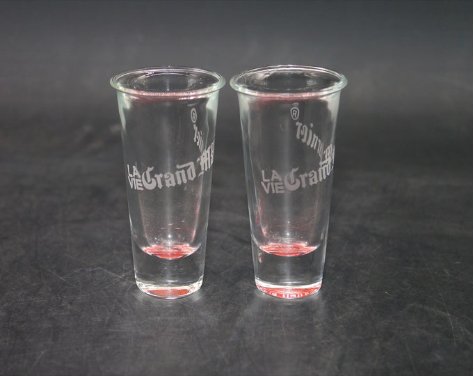 Pair of la vie de Grand Marnier shooter glasses.  Etched-glass branding, red bases.