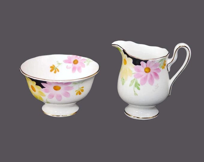 Art-deco era Royal Albert creamer and sugar bowl set. Bone china made in England. Hand-painted black pink yellow flowers, gold edge.
