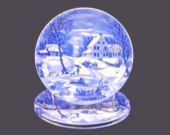 Three Currier & Ives blue-and-white Christmas salad plates.