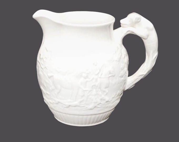 Wedgwood Devonshire 50-ounce pitcher made in England. Embossed hunt scenes, dog handle. Flaw (see below)
