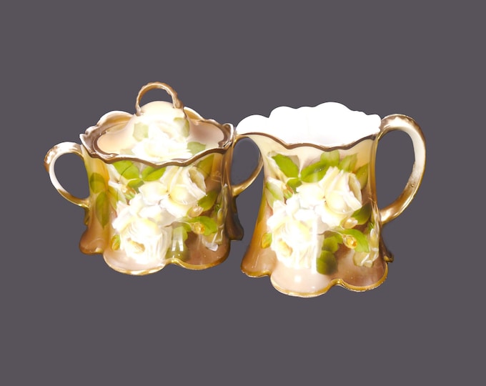 Antique Rosenthal Madeleine creamer and covered sugar bowl signed Tilberth. Green and tan metallic, white roses. Bavaria. Flaws.