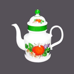 May include: White ceramic teapot with a green lid and a green band around the body. The teapot has a floral design with an orange fruit and green leaves.