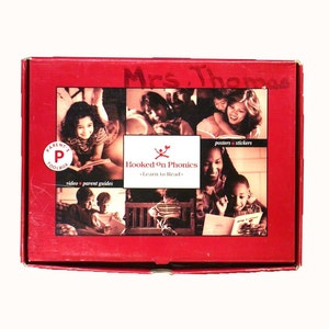 May include: A red box with the words "Hooked On Phonics" and "Learn to Read" on it. The box has images of children and adults reading. The box also has the words "Parent's Toolbox" and "video parent guides" on it.