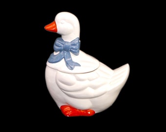 Duck cookie jar with blue bow. Matches with the Marmalade series. Made in Taiwan for Sophia Ann. Flaw (see below).