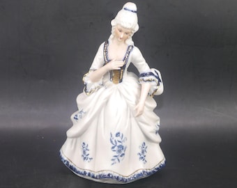 Vintage Dresden-style porcelain bisque figurine of woman in period Victorian dress.