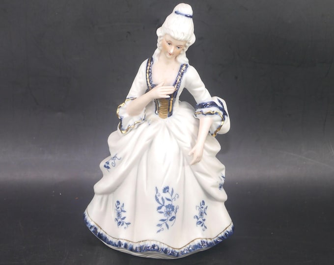 Vintage Dresden-style porcelain bisque figurine of woman in period Victorian dress.
