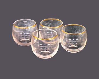 Four Acadian Distillers roly-poly lo-ball glasses with gold rims, etched-glass branding.