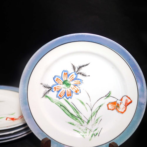 Nice pieces of hand-painted Nippon lilac lusterware. Orange florals, shops lilac luster. Five dessert plates, two tea sets.
