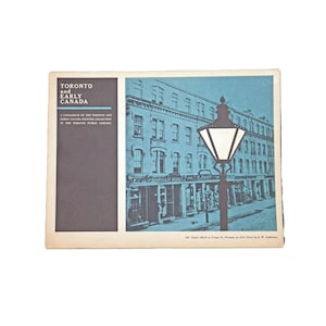 May include: A black and white photo of a street scene in Toronto, Canada. The photo shows a street lined with buildings, with a street lamp in the foreground. The text "Toronto and Early Canada" is visible in the upper left corner of the image.