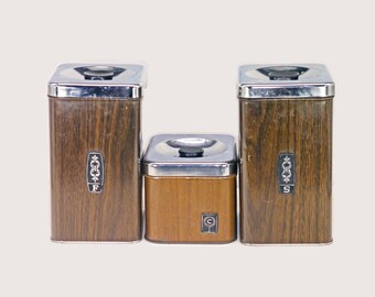 Three retro Ekco faux woodgrain canisters sugar, flour, and coffee. Chrome lids. Made in Canada.