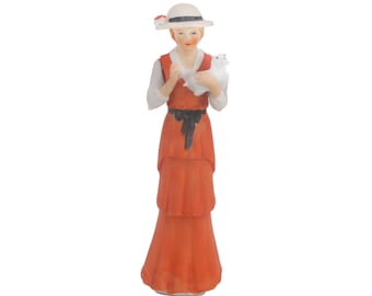 Porcelain bisque figurine of woman holding dog | lamb. Made in Korea. Blue crossed swords mark to base. Unknown manufacturer.
