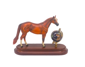 Ceramic horse figurine on wood base. Murano rotating world globe.