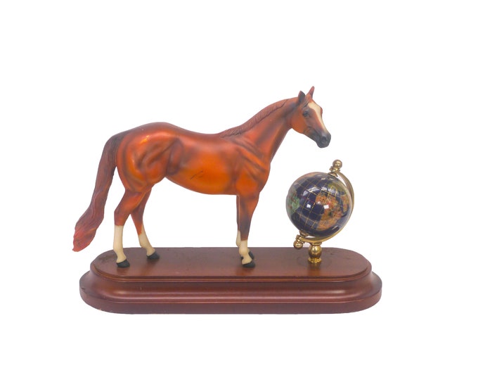 Ceramic horse figurine on wood base with Murano glass rotating world globe.