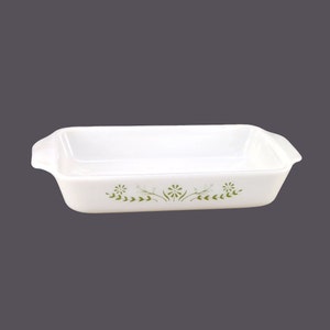 May include: White rectangular baking dish with green floral design. The dish has two handles on the sides.