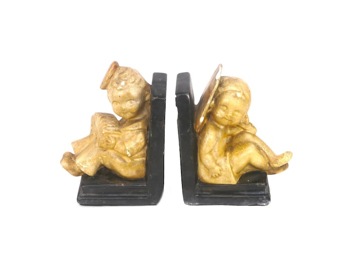 Pair of mid century chalk ware book ends. Oriental children one with fan the other with accordion. Chips (see below).