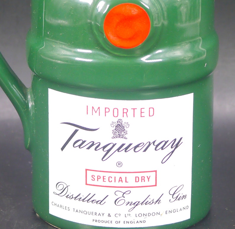 May include: A green ceramic bottle with a red seal and a white label. The label reads "IMPORTED Tanqueray SPECIAL DRY Distilled English Gin CHARLES TANQUERAY & CO LTD. LONDON, ENGLAND PRODUCE OF ENGLAND".