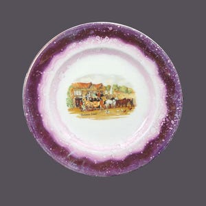 May include: A white ceramic plate with a purple rim and a scene of a horse-drawn carriage in front of a building. The scene is titled "Dickens' Days".