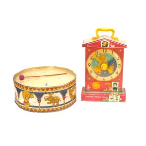 Pair of vintage toddler toys. GSW metal drum with wooden drumstick, Fisher Price Music Box Teaching Clock #998.