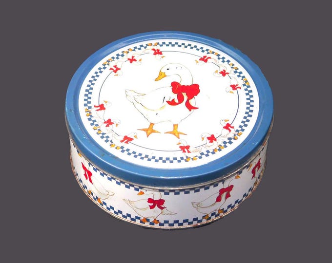 Round cookie tin. White geese, red ribbons, blue checks. American Trends Corp.