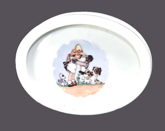 Antique porridge or oatmeal bowl made in Czechoslovakia. Girl, doll and dog in center.