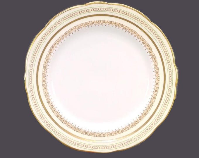 Foley bone china dinner plate made in England. Golden circles, five-petaled flowers on yellow with green bands. Flaw (see below).