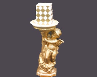 Gilded plaster paris cherub candle holder with square harlequin candle. Attributed 1980s.