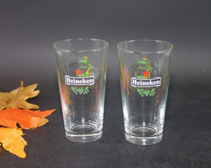 Pair of Heineken 60 Jaar New Year's half-pint beer glasses. Etched-glass branding, frog with horn.