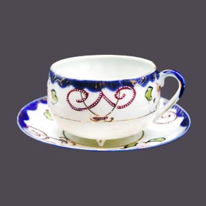 Art-deco era hand-painted Nippon moriage tea set (quad-footed cup with saucer). Cobalt, gold, maroon swirls, flowers.