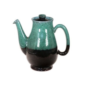 May include: A green and black ceramic teapot with a rounded body and a lid. The teapot has a spout and a handle.