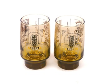 Pair of amber glass cocktail glasses. Etched-glass branding. Silver Crown Gin, Alberta Pure Vodka, Royal Marine Rum.