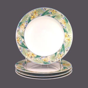 May include: Set of three white ceramic dinner plates with a green, yellow and blue floral border. The plates feature a tropical floral design with yellow flowers and green leaves.