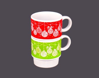 Pair of retro stackable ceramic Christmas coffee or tea mugs. Red and green with white Christmas ornaments.