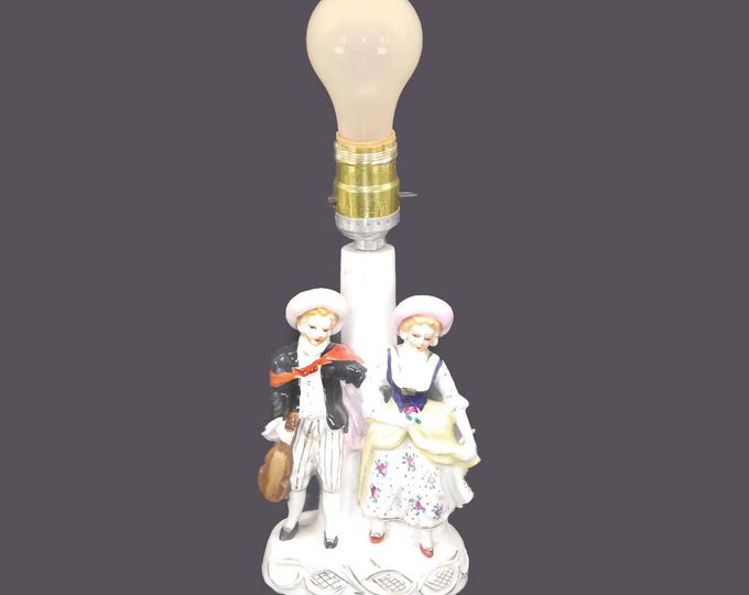 Porcelain table lamp. Two children in period dress with bonnets. Electric.
