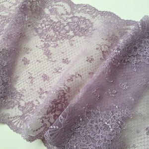 K&ouml;nnte beinhalten: Lilafarbener Spitzenstoff mit einem zarten Blumenmuster. Die Spitze hat eine weiche, flie&szlig;ende Textur und einen dezenten Schimmer.